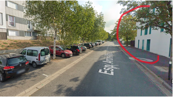 Rue d'accès Esplanade André Malraux, bordée de voitures garées, avec le bâtiment entouré en rouge